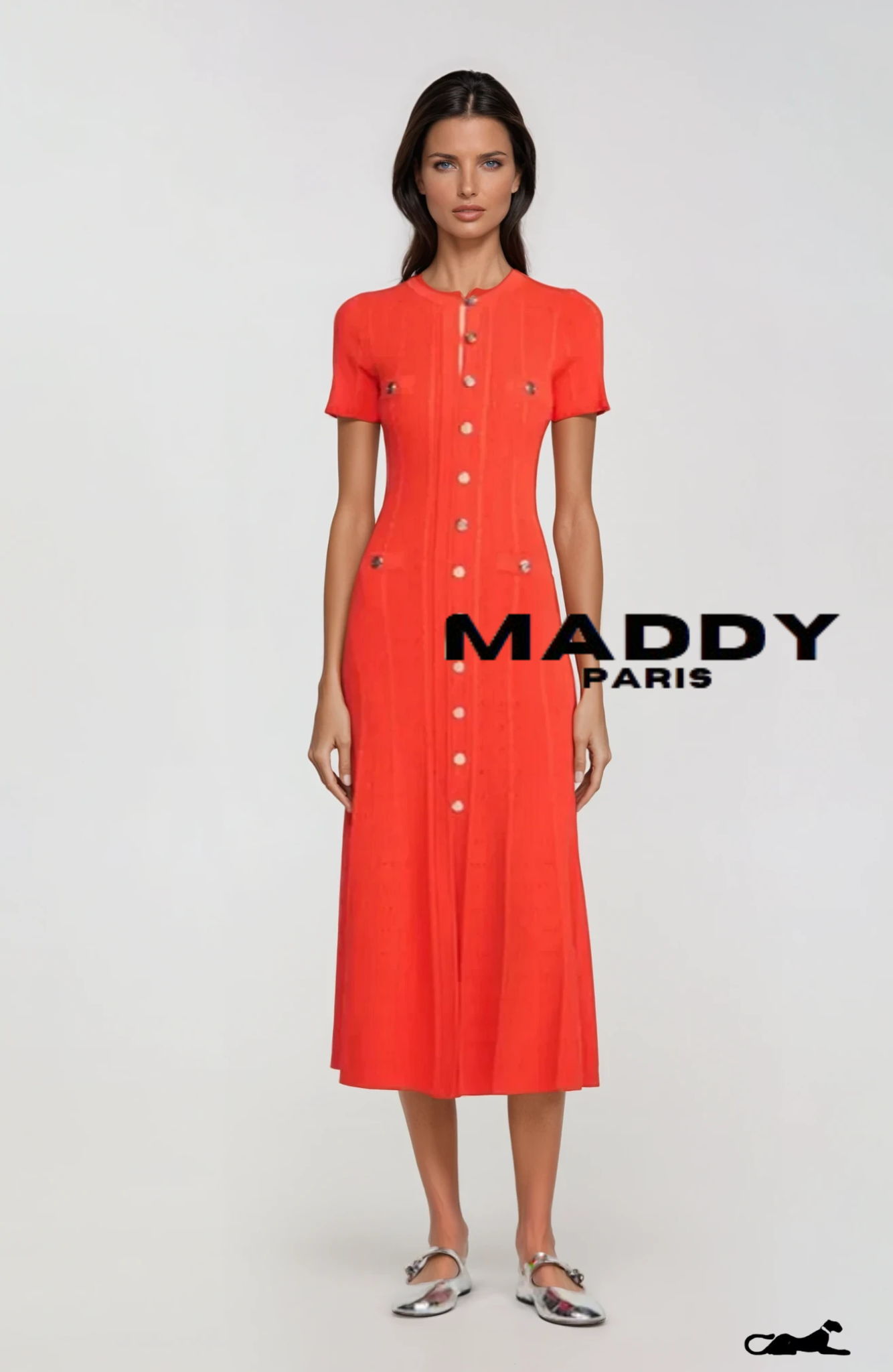 A model wearing a mid-length orange dress with short sleeves and gold buttons down the front, paired with white shoes.