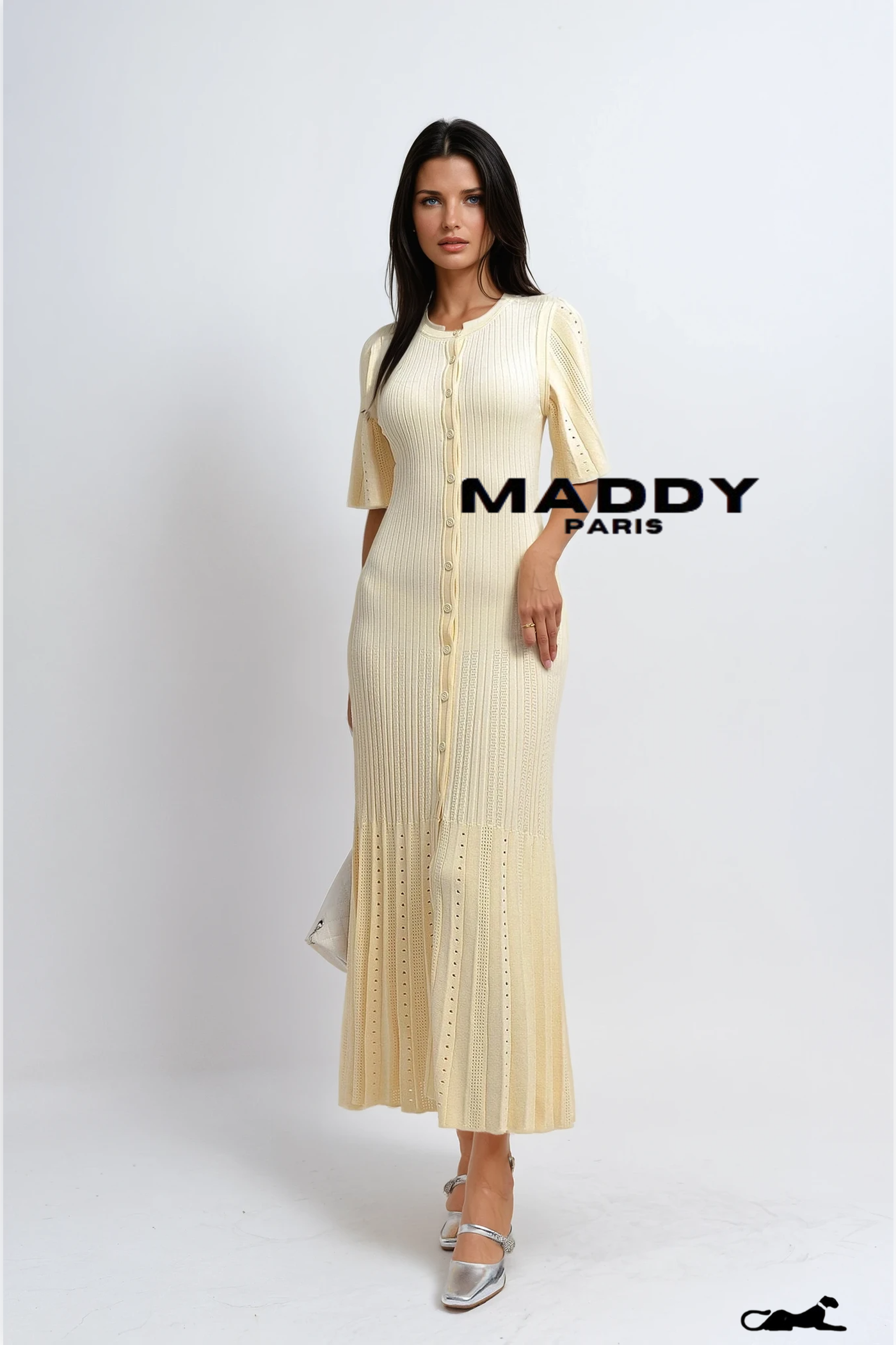Woman wearing a long, light-colored dress with a button-up front on a white background, featuring the brand 'MADDY PARIS'.