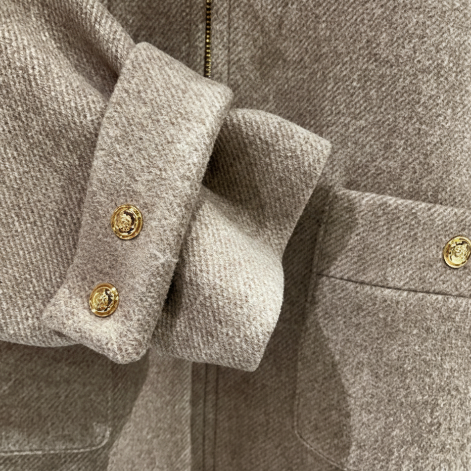 Close-up of a beige coat with gold buttons
